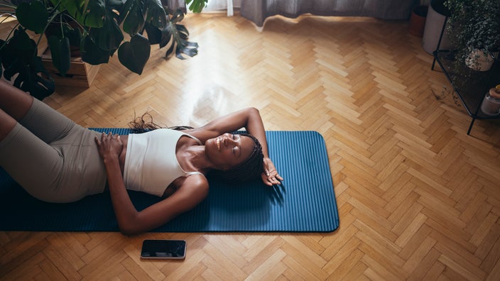 Woman on her yoga mat at home doing floor exercises.