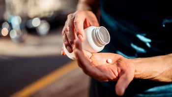 Medication: man pouring pill into palm 1309562024