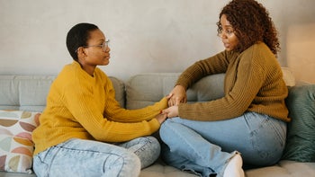sexual health: gen z couple holding hands on the couch 1892308525