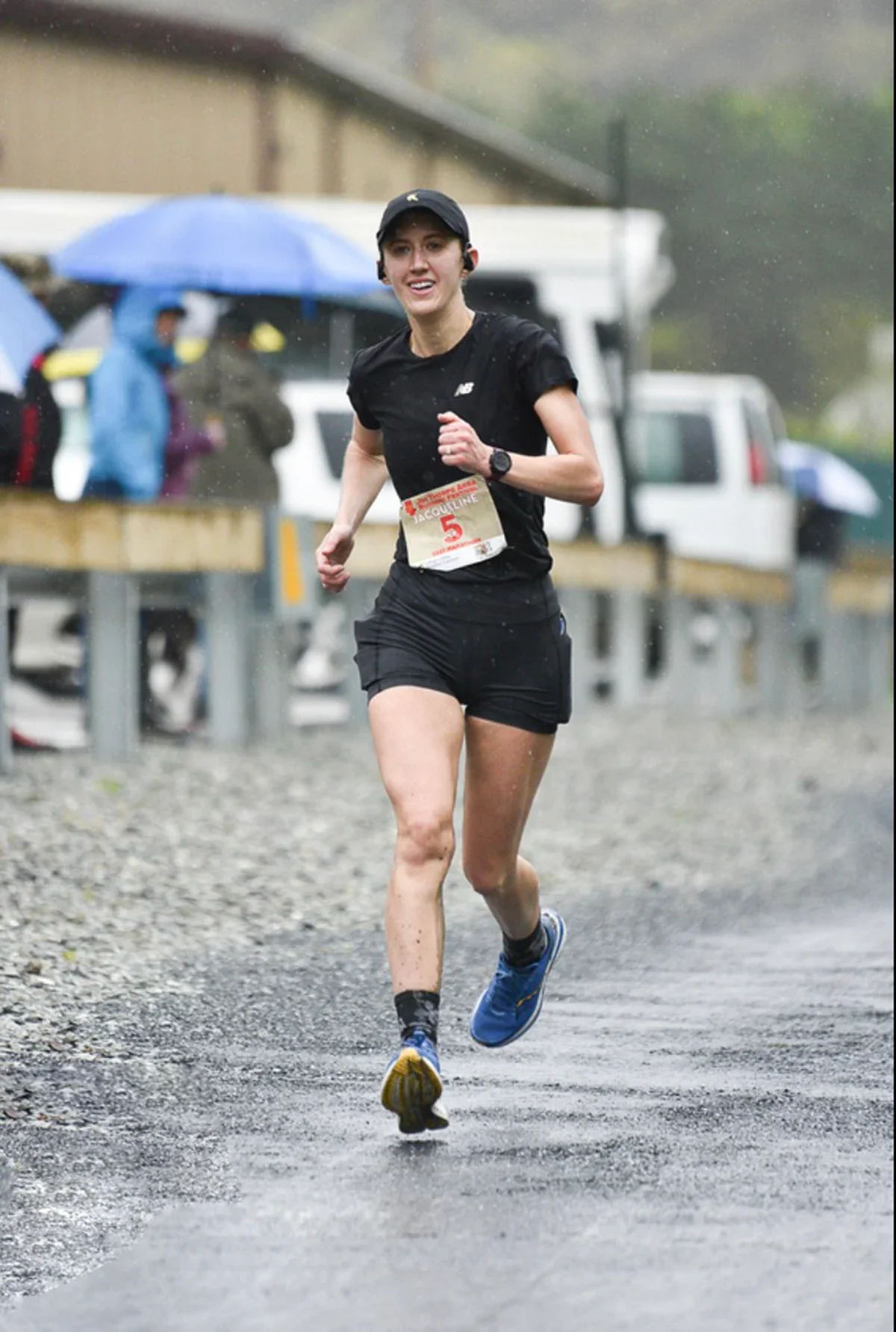 Jacqueline Alnes is pictured running a road race in the rain.