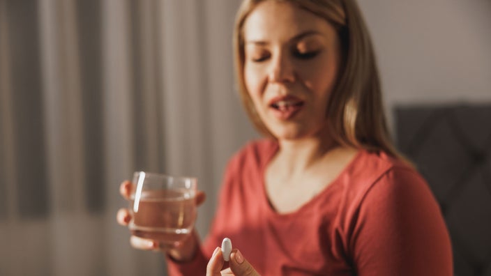 A person taking a supplement before going to bed.