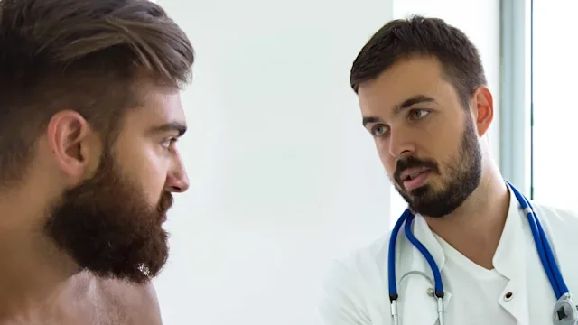 Mens health: breasts: shirtless patient talking to doctor 1142896323