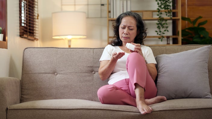 A woman at home takes medication. 