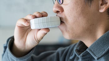 Asthma: closeup man using an inhaler 1821944789