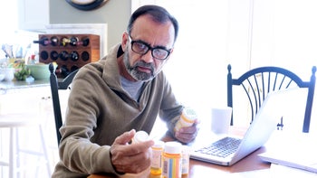 Pharmacy: man reading precription bottle 837648144