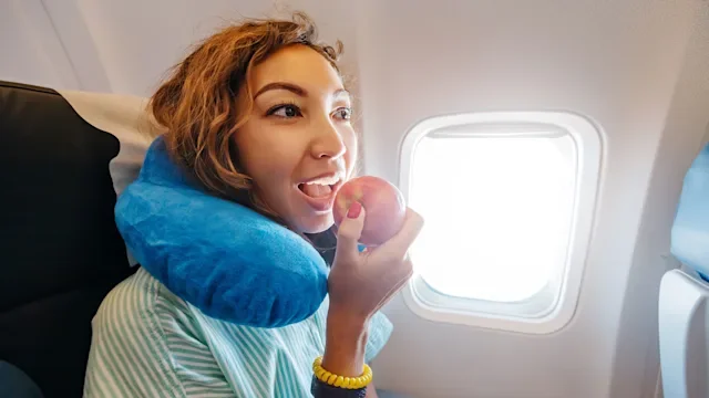 Diet Nutrition: woman eating apple on airplane 1361309961