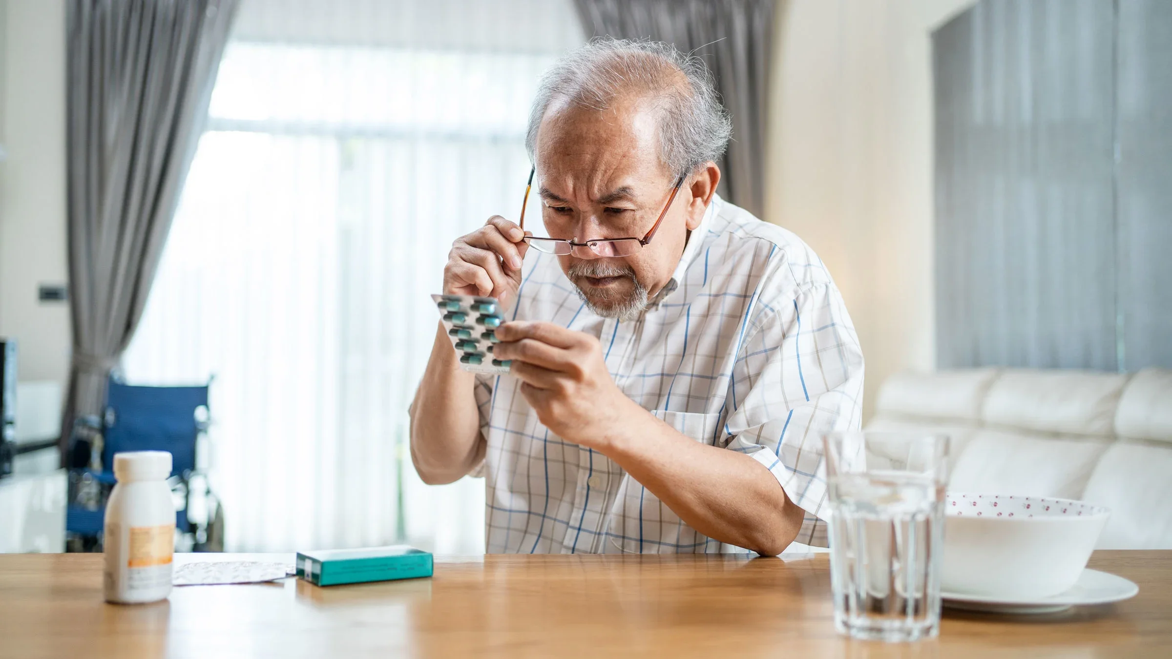 Older adult man reads a prescription at the dining table.
Kiwis/iStock via Getty Images Plus