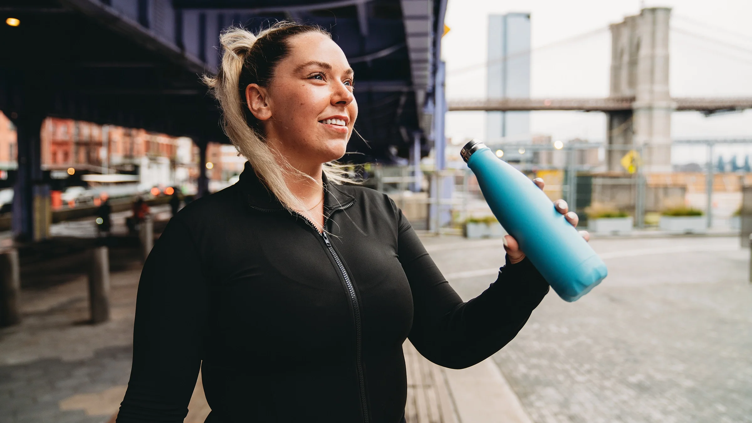 Woman drinking out of a reusable water bottle.