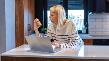 Pharmacy: woman researching medication on the internet 1917848876