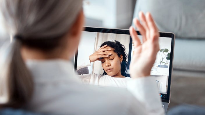 A psychologist uses a tablet for an online consultation with her patient.