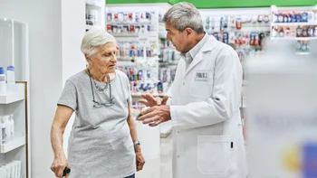Naproxen: senior woman speaking to pharmacist 1455245086