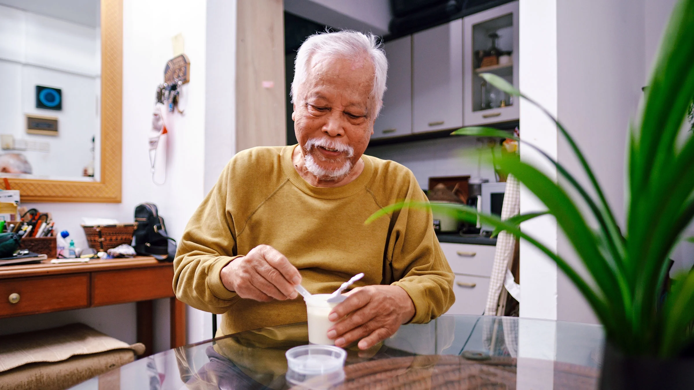A man eats yogurt at home. Yogurt contains probiotics, which promote gut health. Some people who take probiotics say they have diarrhea. But studies show that probiotics don’t cause diarrhea.