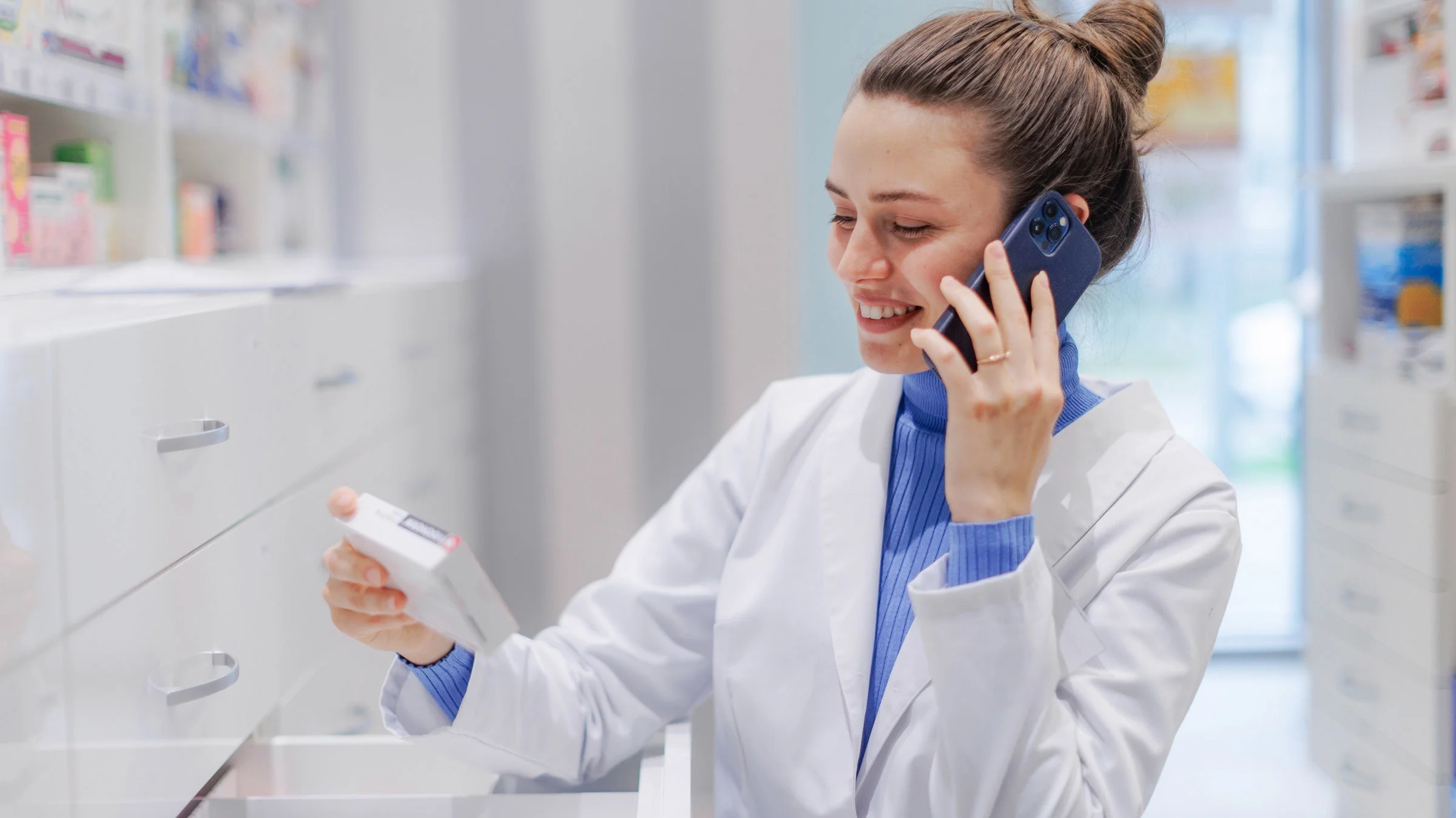 A pharmacist in a phone call while checking stockroom.