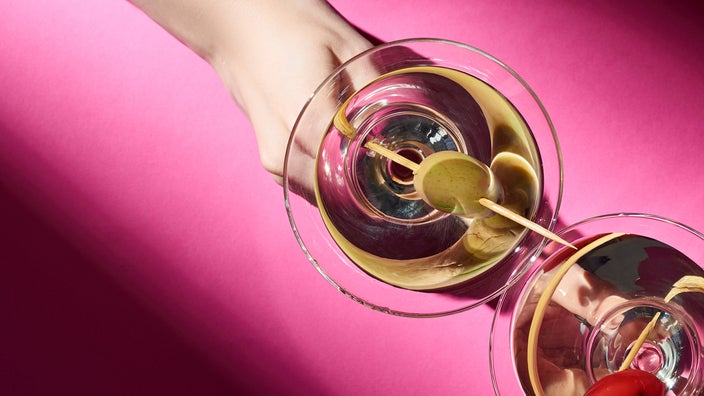 Close-up of a woman’s hand holding a martini glass.