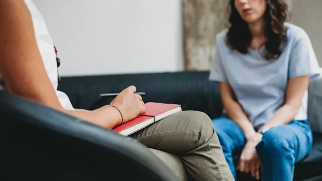 Mental health: woman speaking to therapist 1140393669