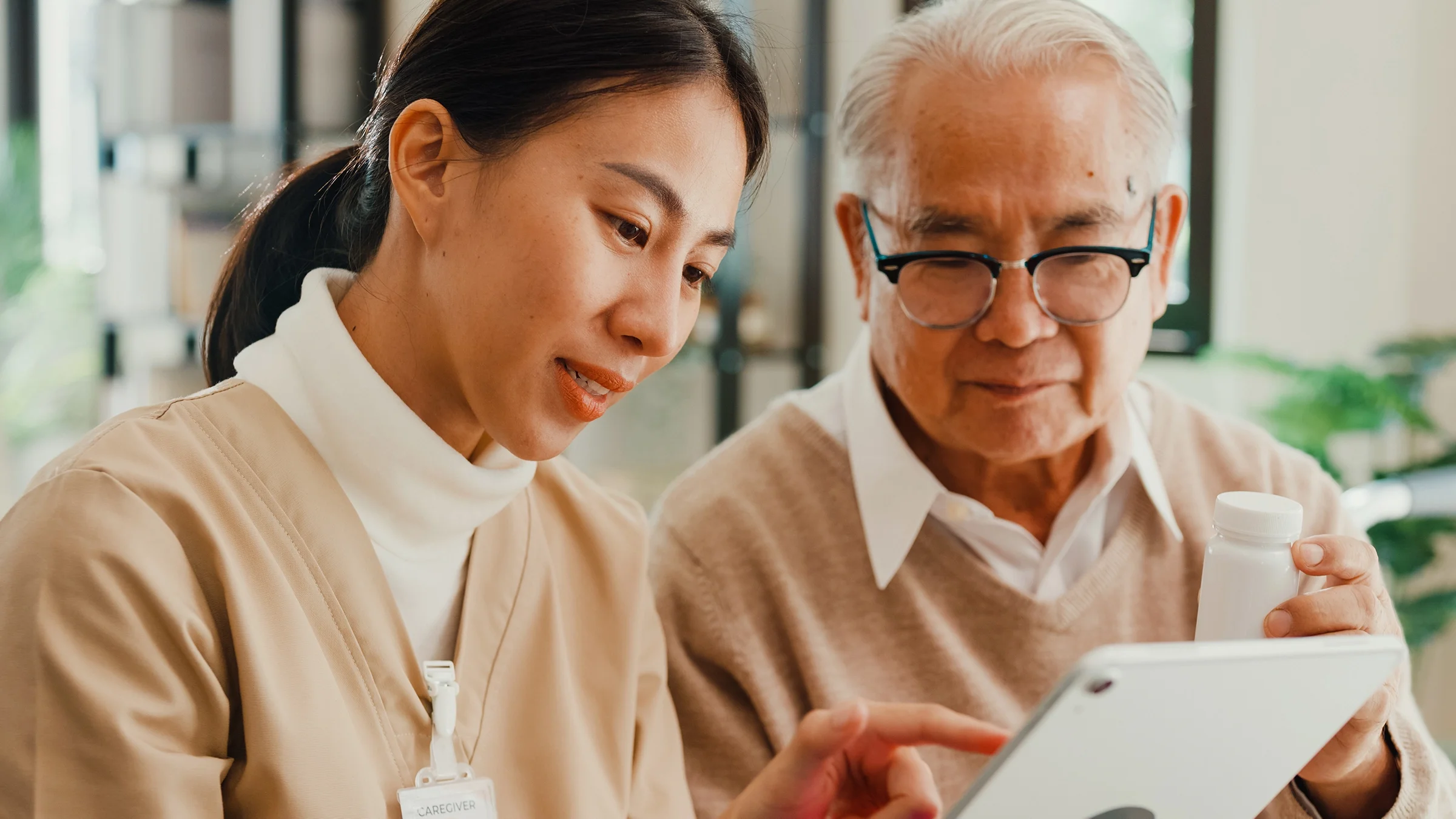 A nurse explains medication information to a senior patient.