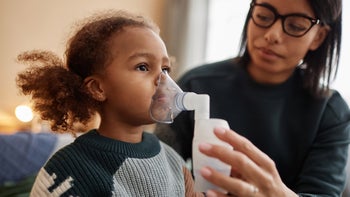 Respiratory: mother holding nebulizer to daughters face 1933645853