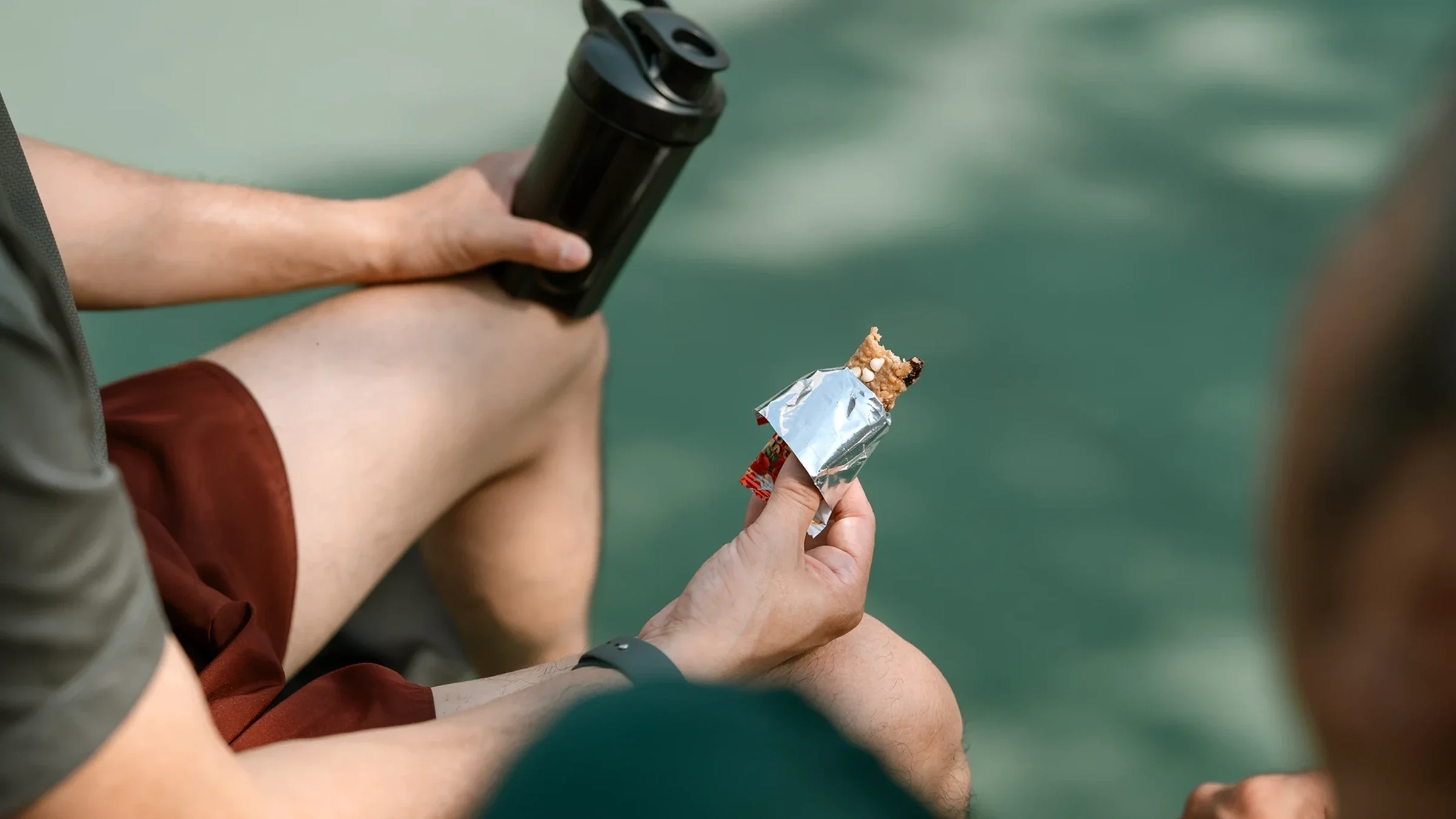Close-up man eating a protein bar.