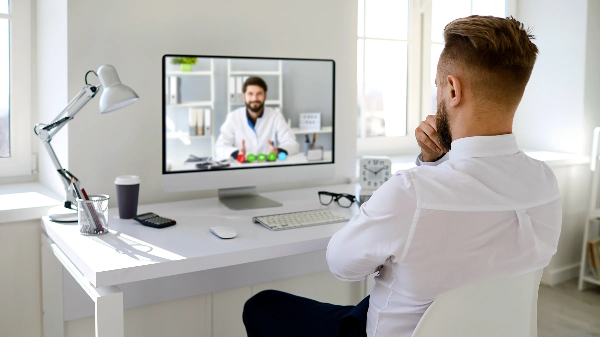 A man talks to a doctor online during a telehealth appointment.