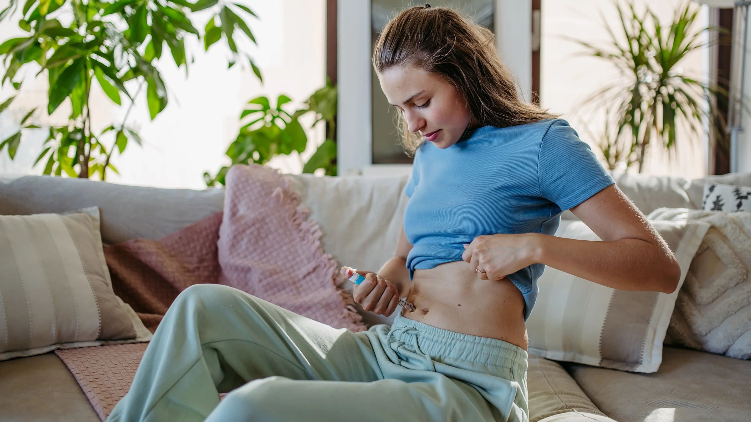 A woman injects insulin into her abdomen.