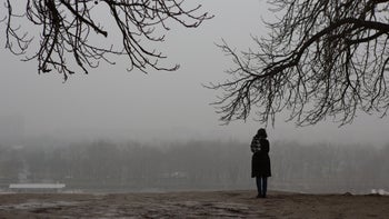 Health: Research: back of woman standing in winter field-1129211949