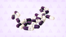 A pile of white and purple capsule pills is pictured against a light-purple, warning-sign background.
GoodRx Health