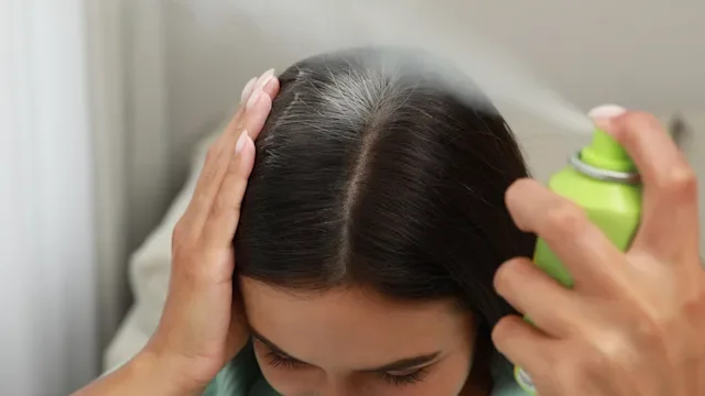 Hair: woman using dry shampoo 1331250679