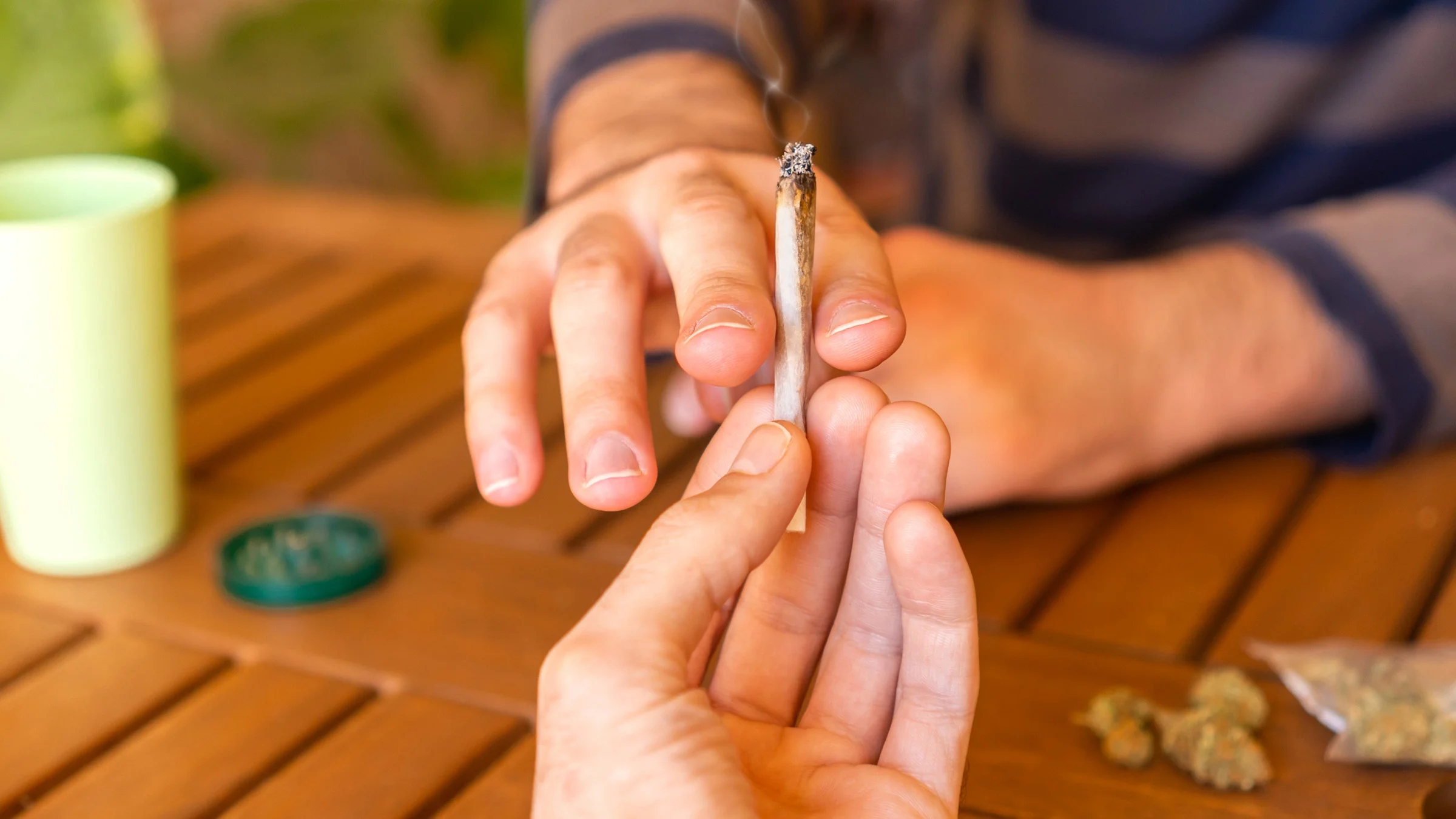 Close-up of a weed joint being passed.