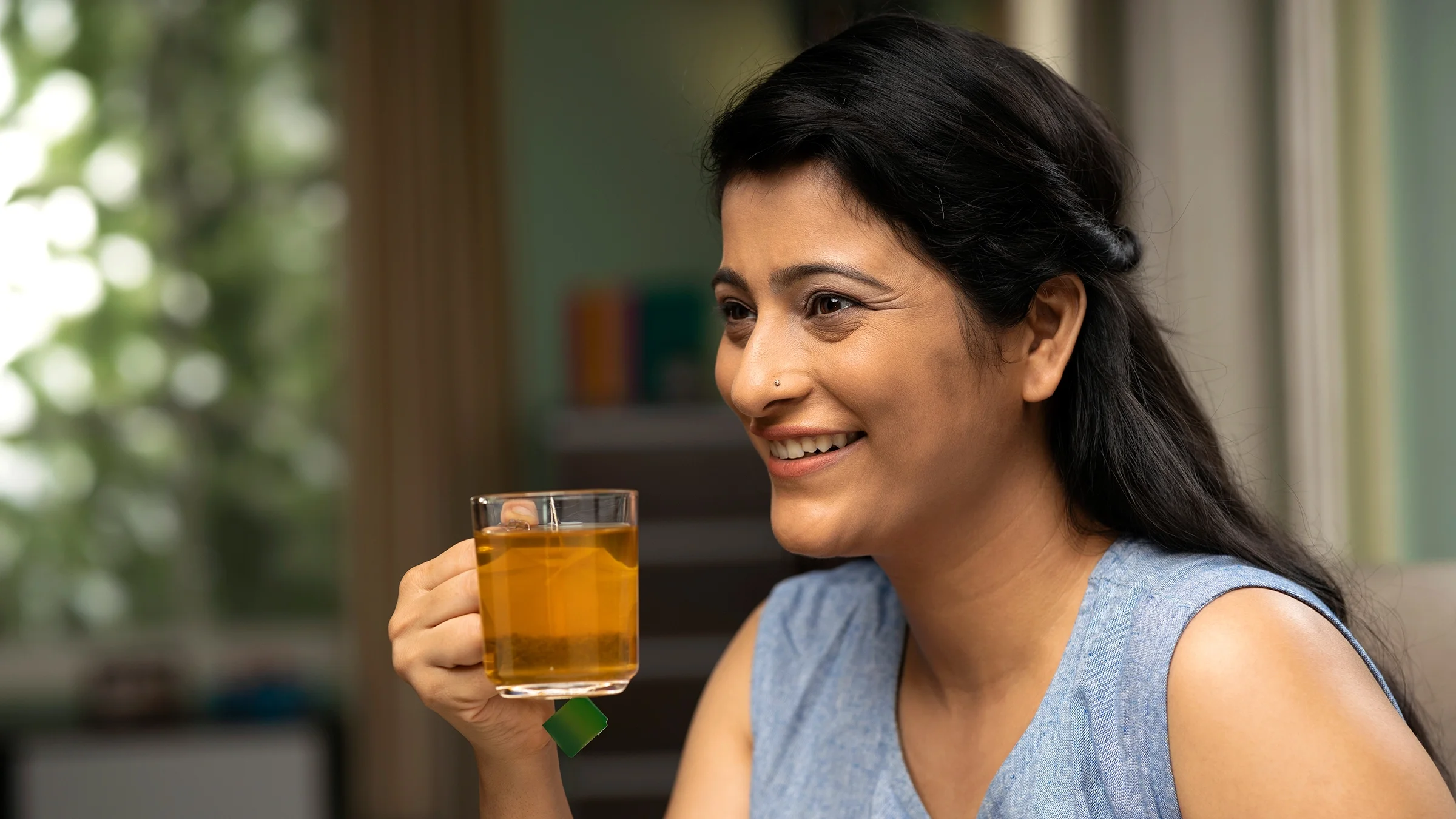 Woman drinking cup of tea at home.
