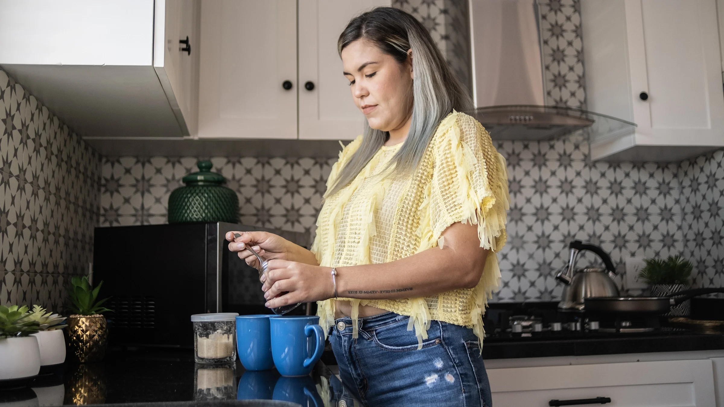 A woman prepares instant coffee at home.