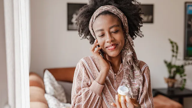Medication: woman on phone holding rx 1310985956