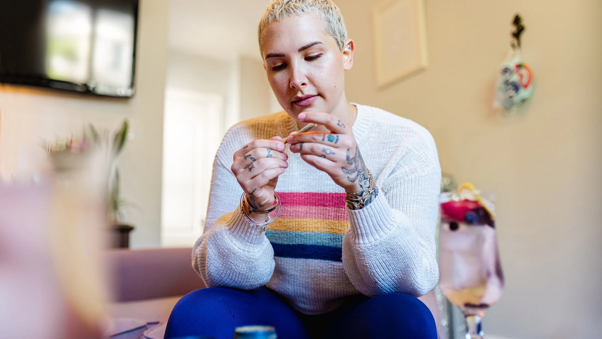 A woman rolls a joint of marijuana.