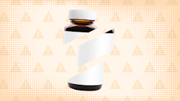 In the center of a light orange-brown background with texture and warning sign pattern is a brown glass pill bottle with a white label cut into thirds. 
GoodRx Health