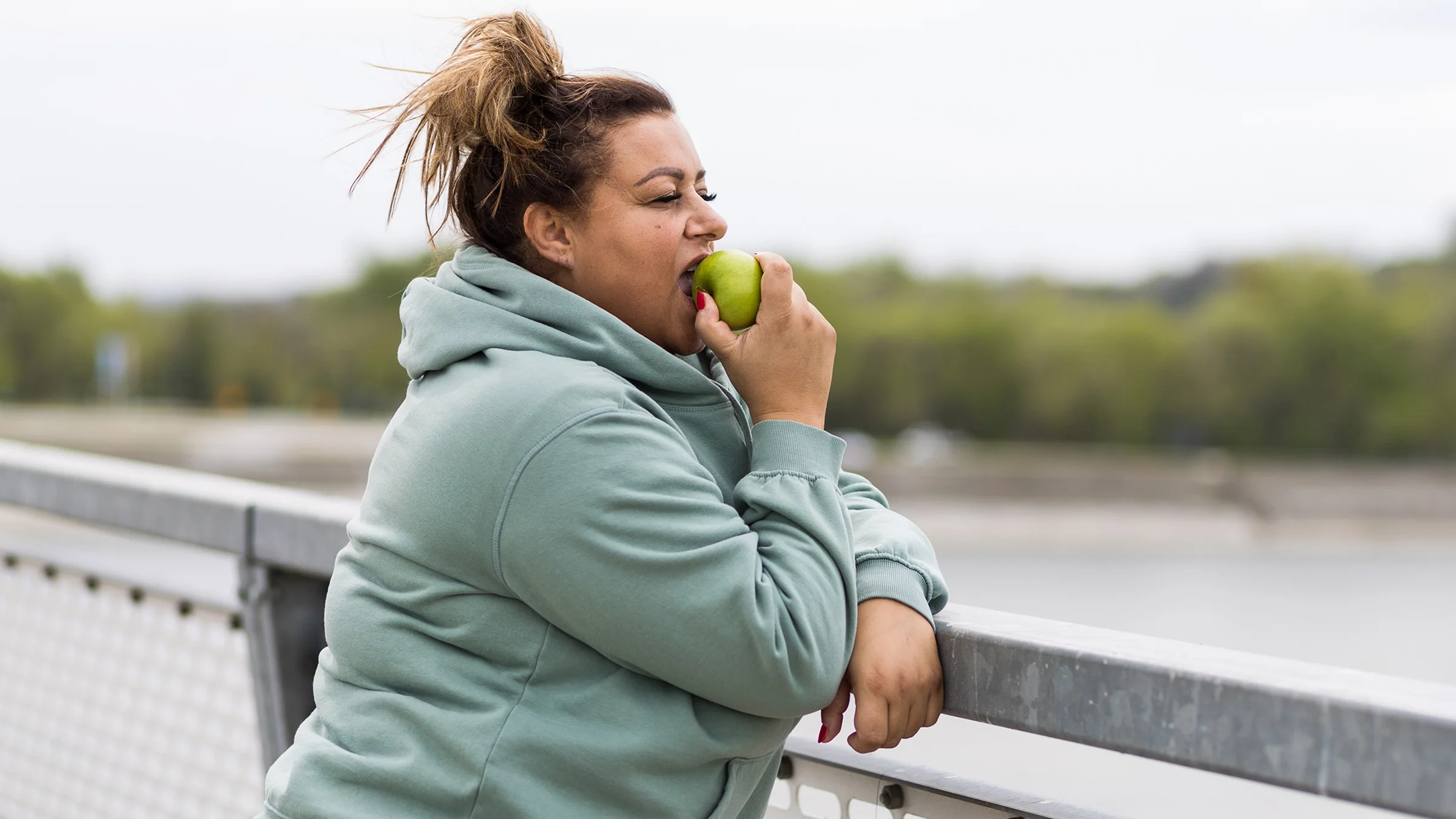 Woman biting into an apple.