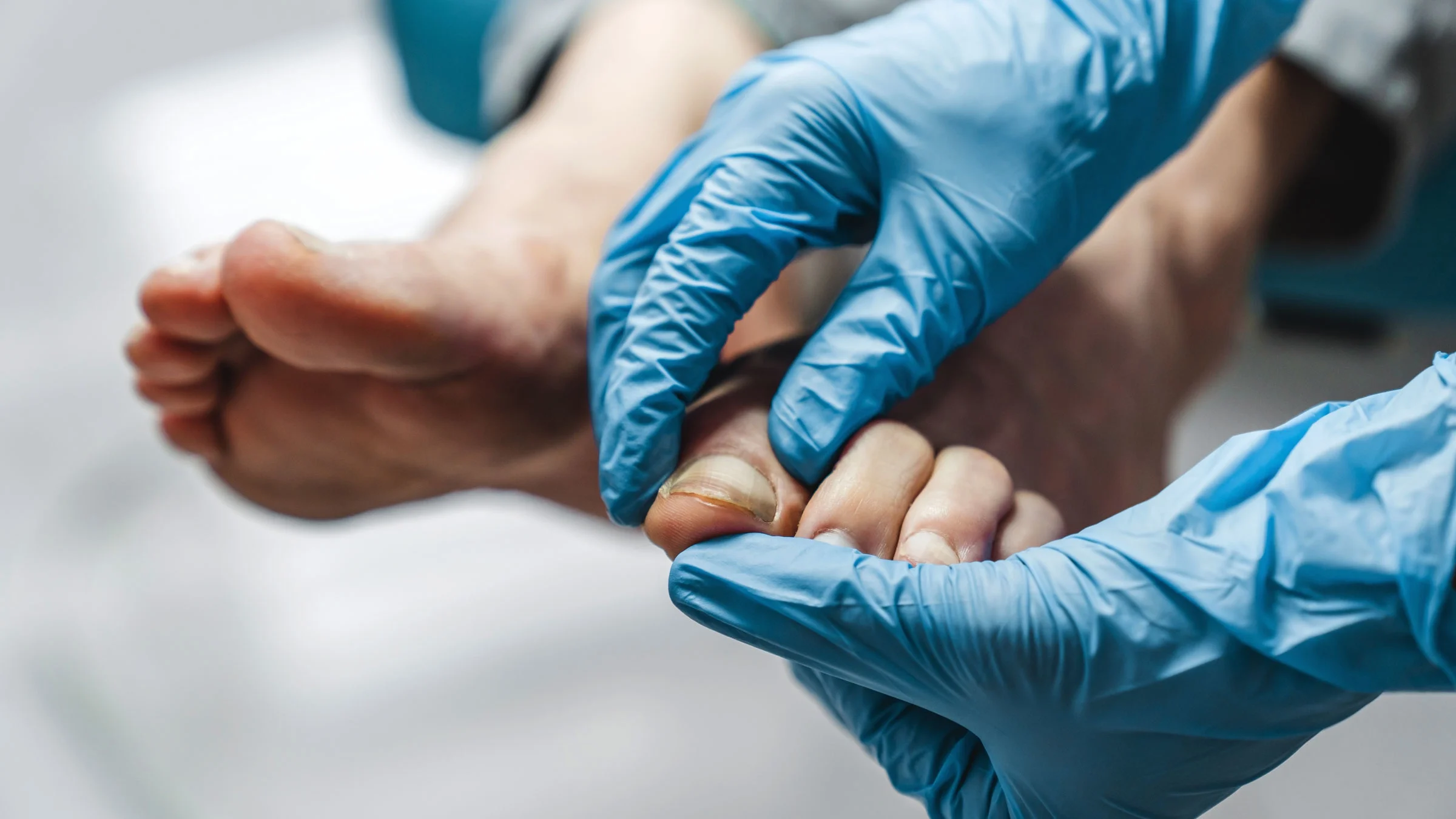 A podiatrist examines a toenail.