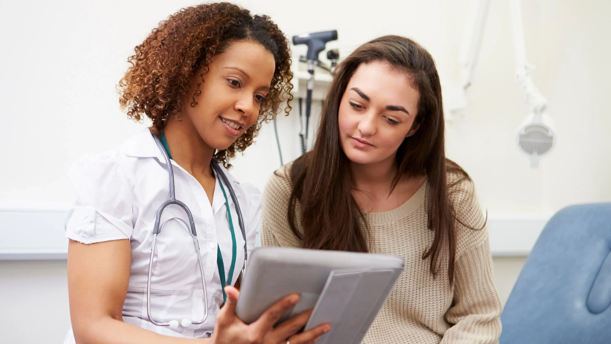 A nurse showing a tablet to a patient.