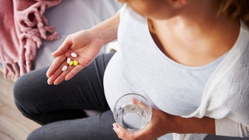 top view pregnant woman taking medicine 964843208
