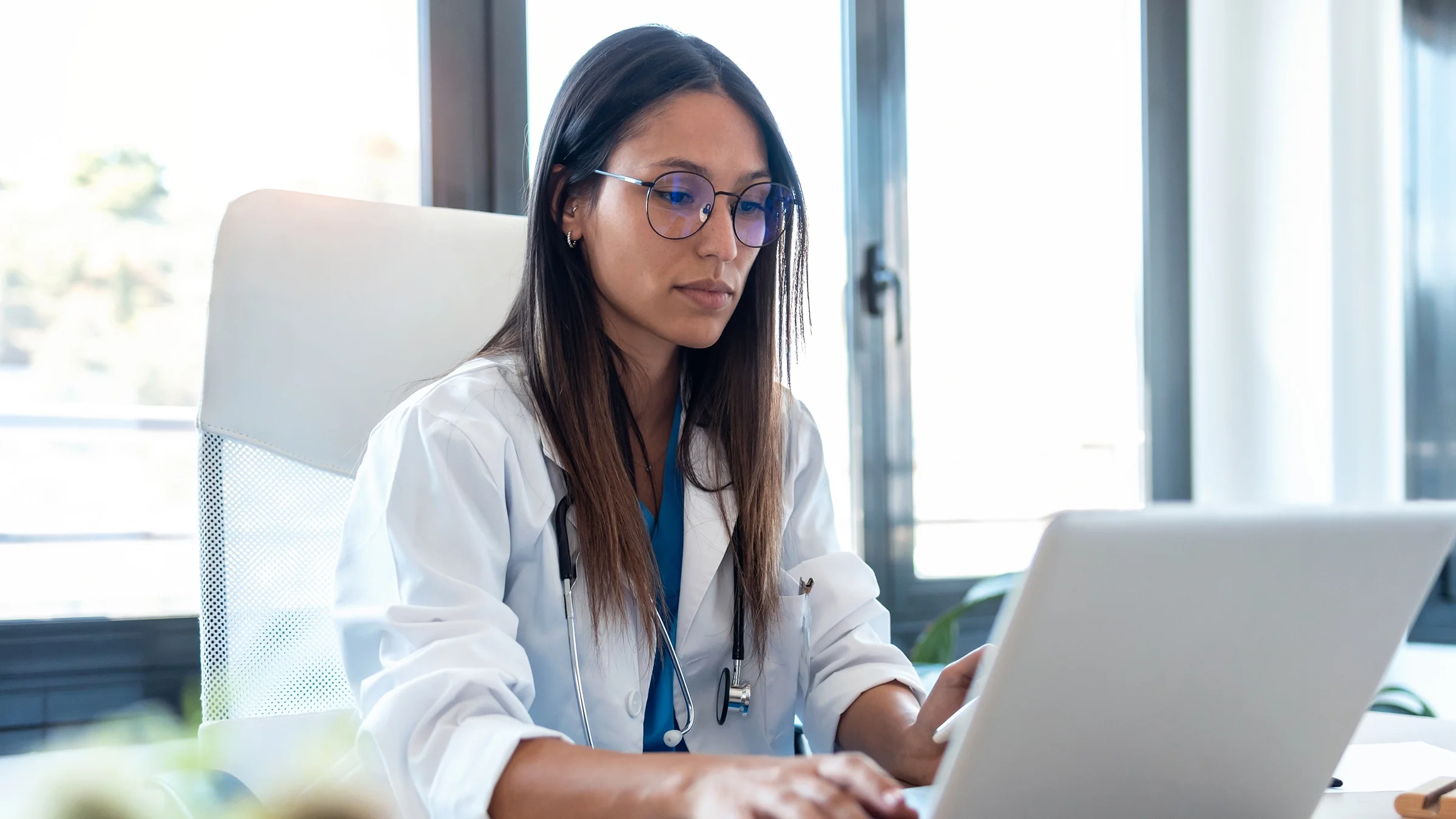 A young doctor works at her laptop in the office.