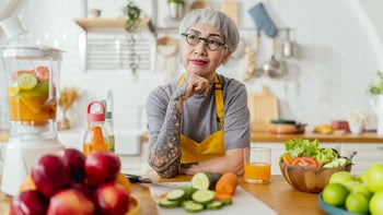 Diet nutrition: senior woman cutting vegetables 1410832492