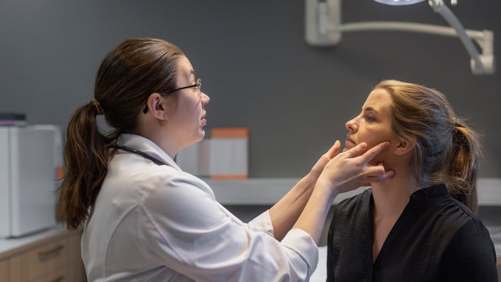A healthcare professional examining a patient in a clinic.