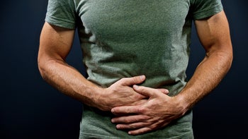 Health: gastrointestinal-infection: cropped shot man holding stomach in pain musles and vains showing-917052736