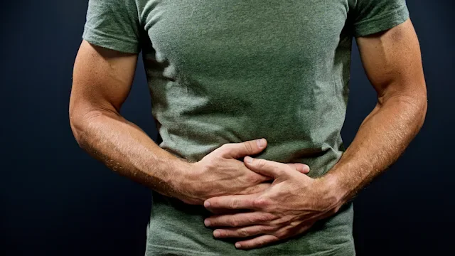 Health: gastrointestinal-infection: cropped shot man holding stomach in pain musles and vains showing-917052736