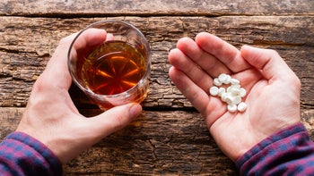 Health: Finasteride: hands holding alcohol and pills-583694202