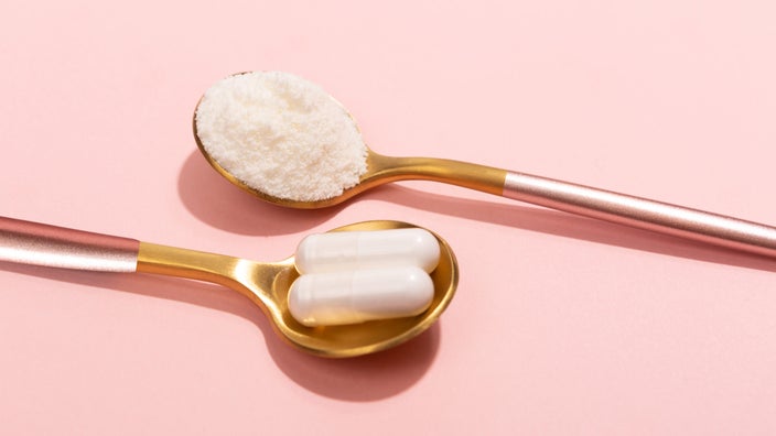 White supplement pils and powder on spoons.