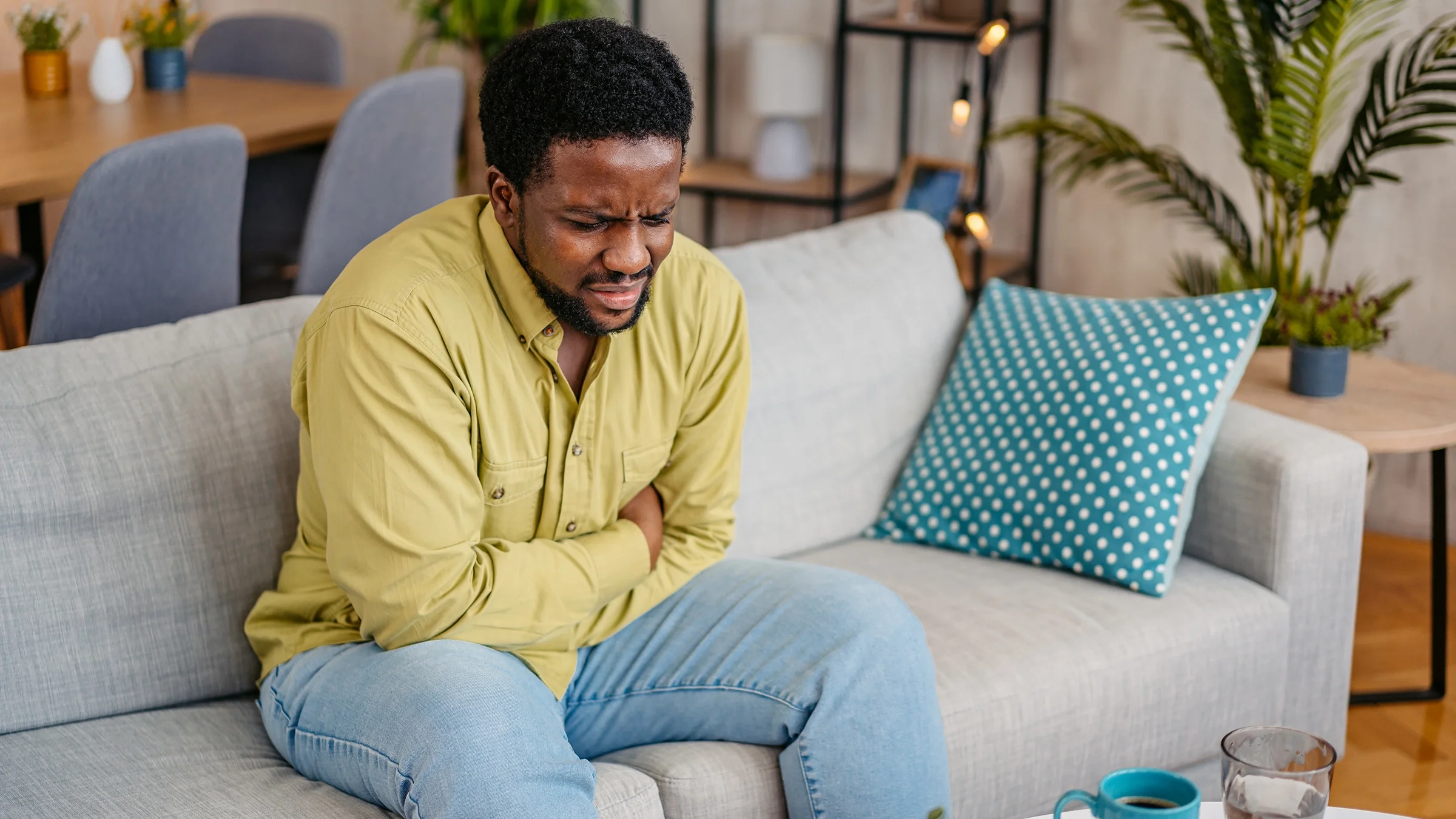 Man having stomachache on the sofa.