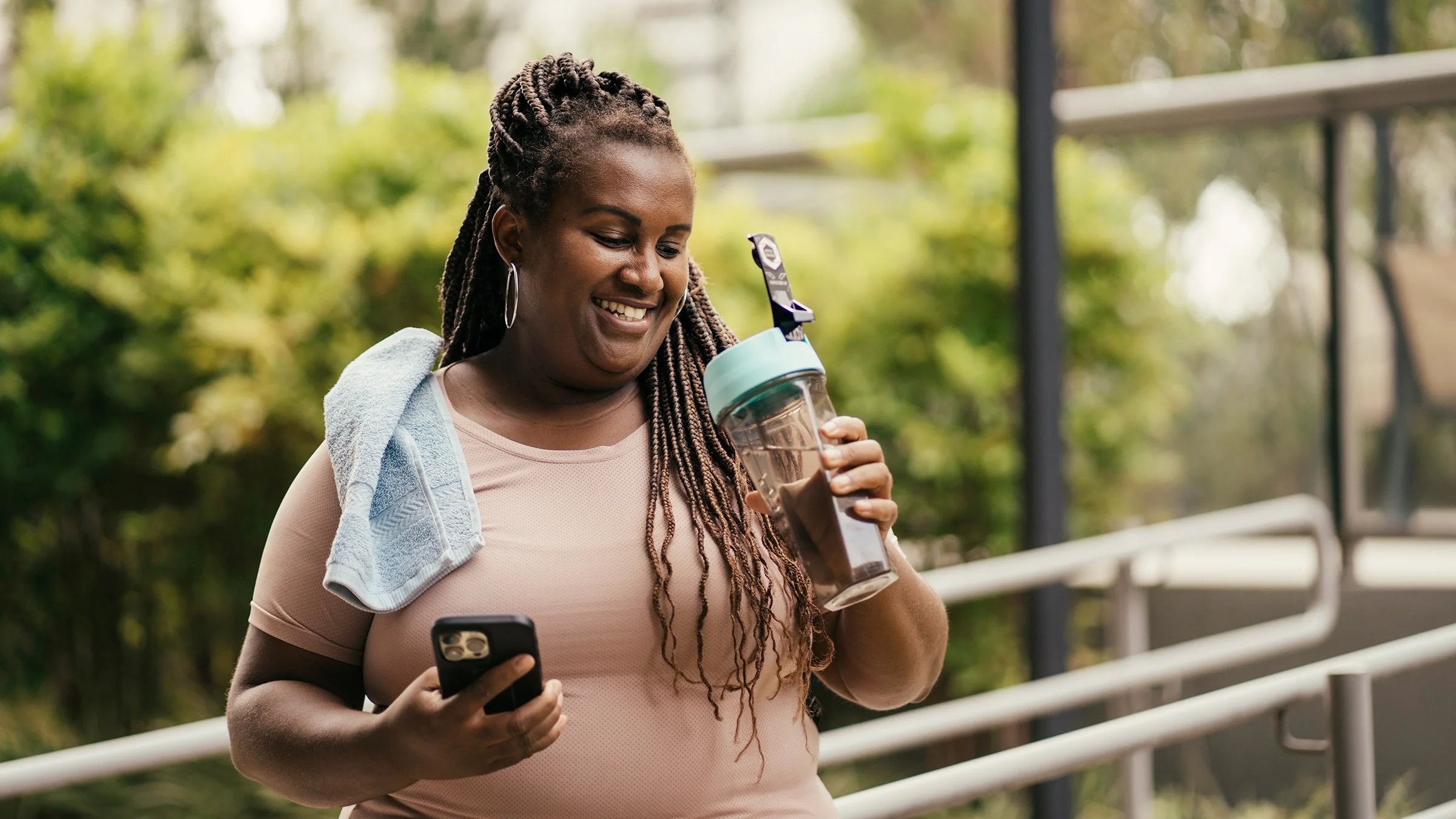 A woman is hydrating after working out.