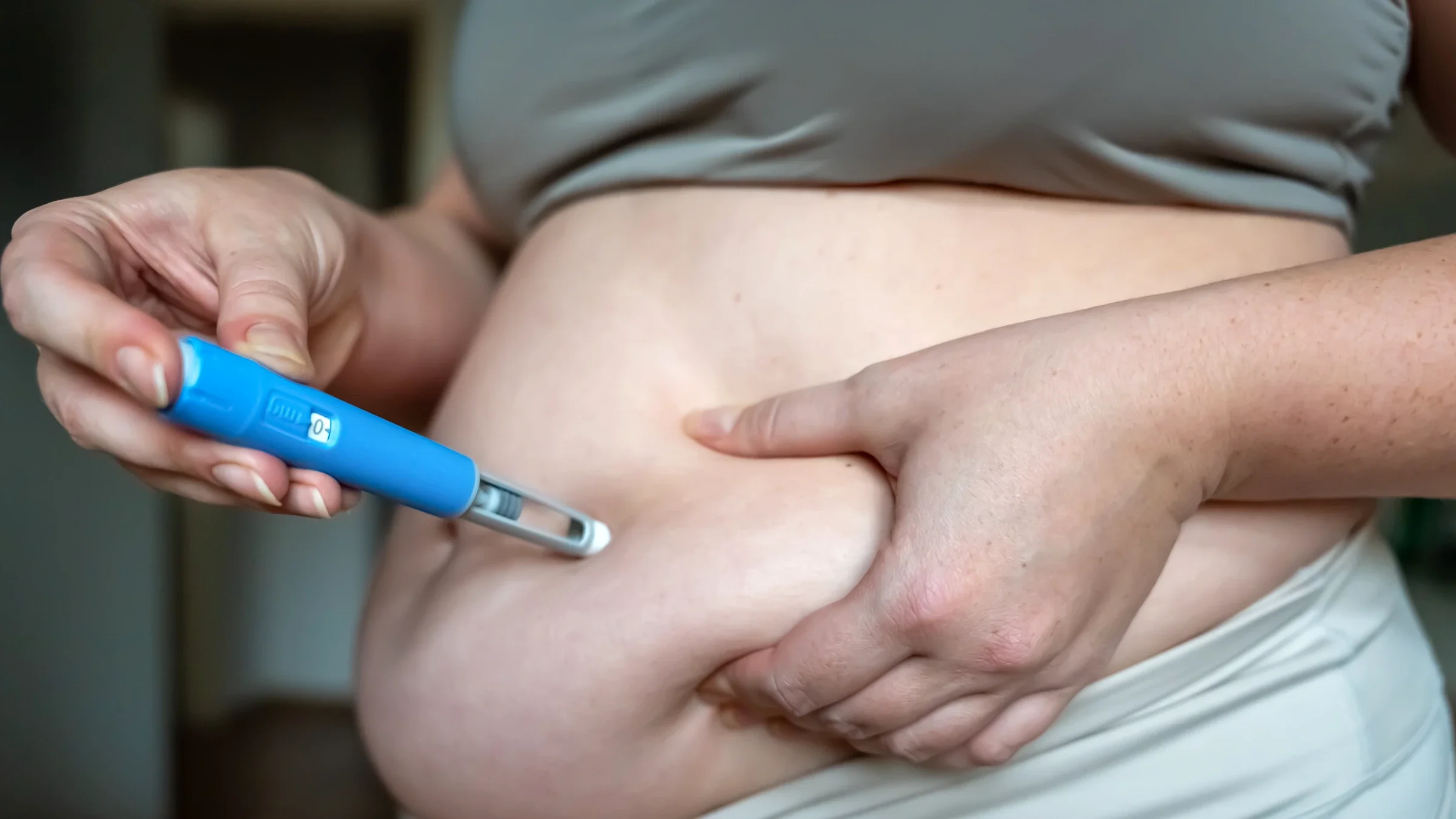 Woman injecting a GLP-1 weight loss medication into stomach