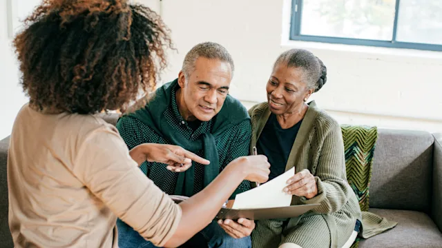 Medicare: Insurance: senior couple with financial advisor 1053987380