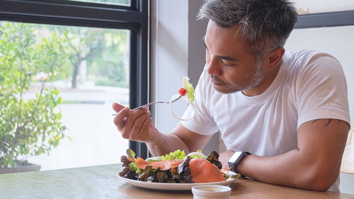 A man eats a salad. 