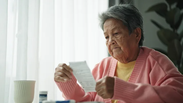 Research: senior woman reading medical instructions 2161658680